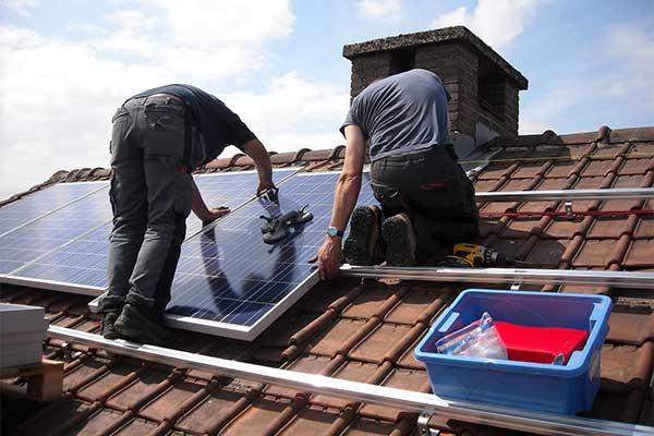 Technicians installing rooftop solar panels